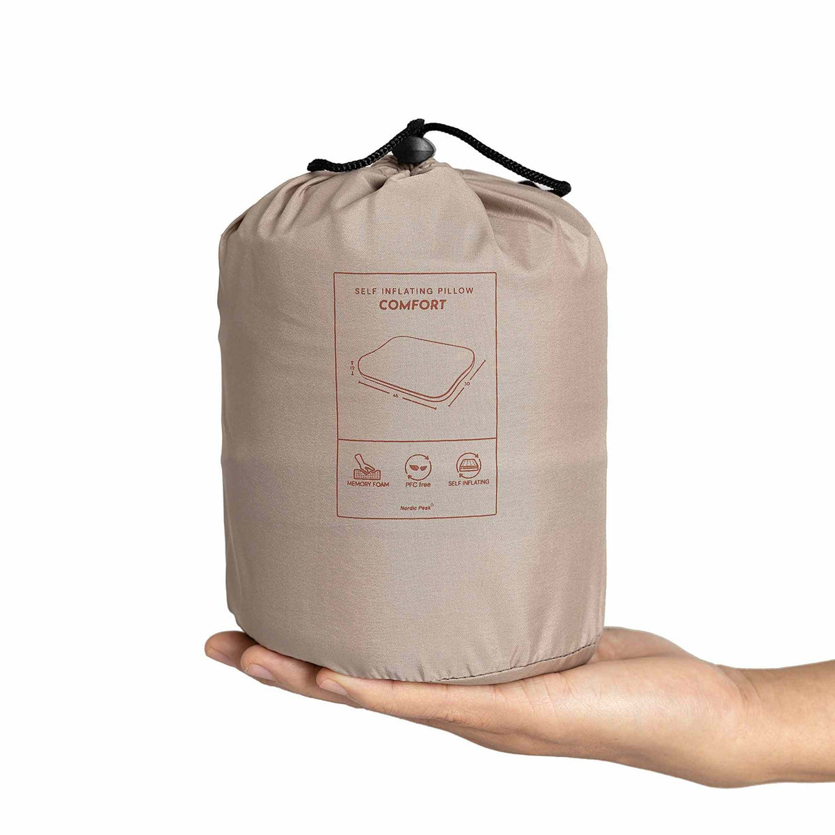 Self-inflating pillow in compact form held in hand, ideal for travel and camping.