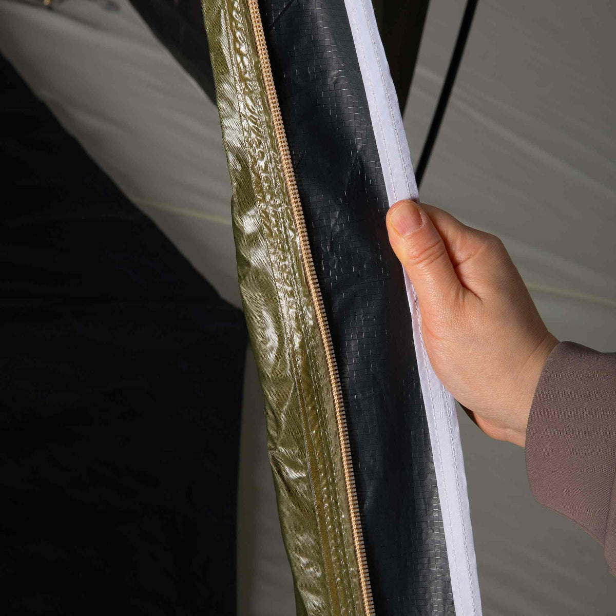 Hand showing blackout lining inside 2-person XL tent.